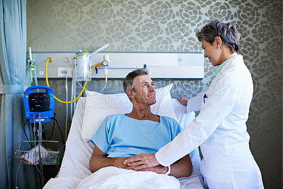 Buy stock photo Shot of a doctor talking to a patient in a hospital ward