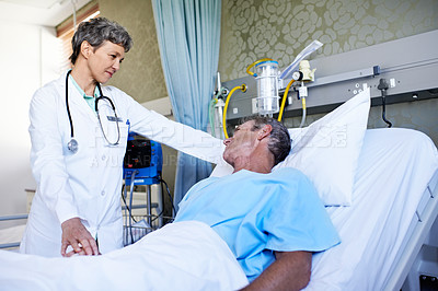 Buy stock photo Shot of a doctor talking to a patient in a hospital ward