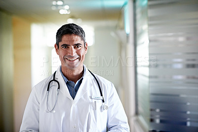 Buy stock photo Portrait of a mature male doctor standing in a hospital corridor
