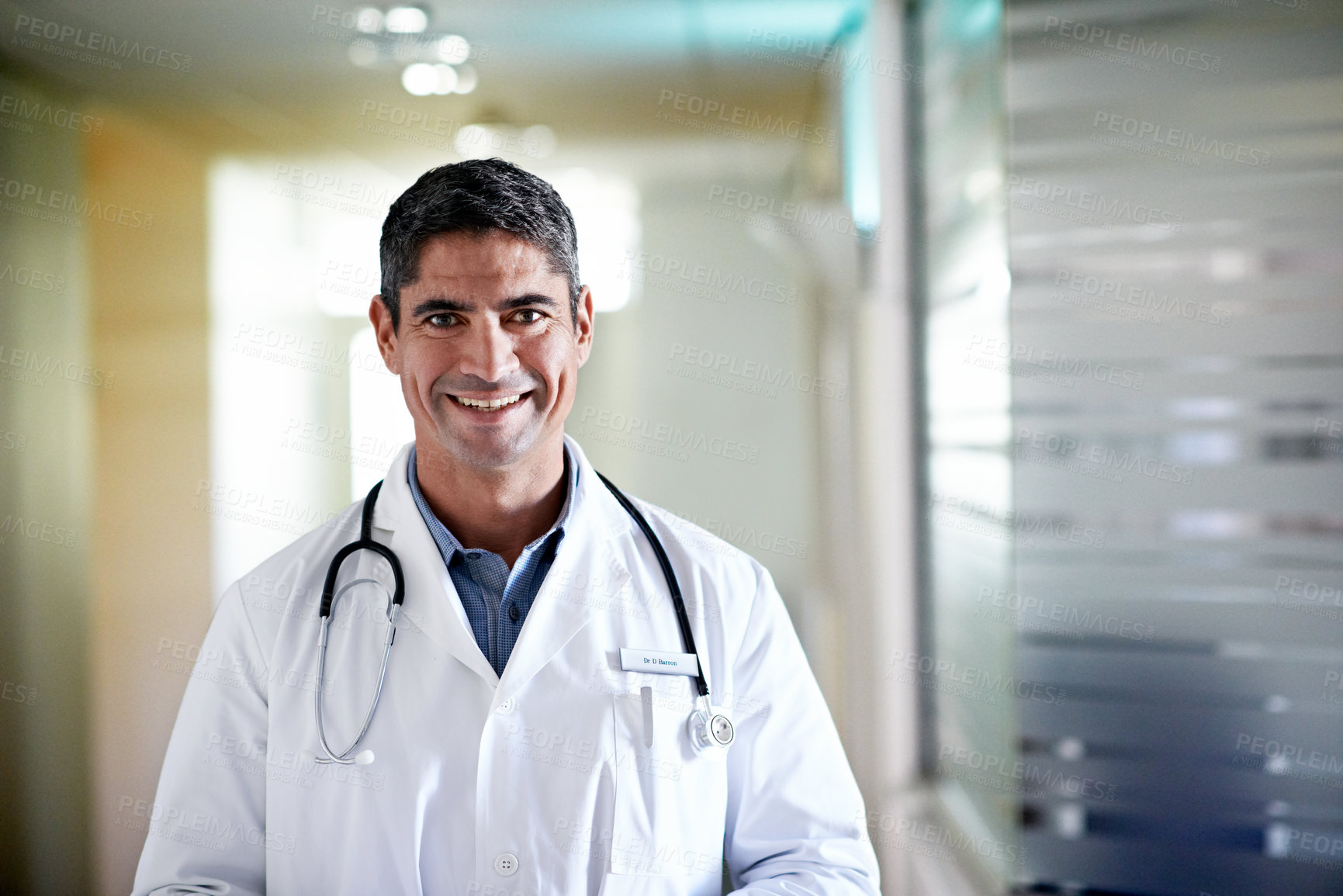 Buy stock photo Portrait, doctor and happy man in hospital for healthcare service, career integrity and experience. Person, medical professional and physician for wellness, about us and smile at hallway in Canada