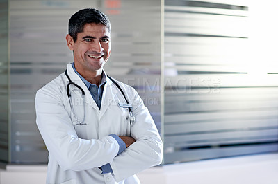 Buy stock photo Portrait of a mature male doctor standing in a hospital corridor