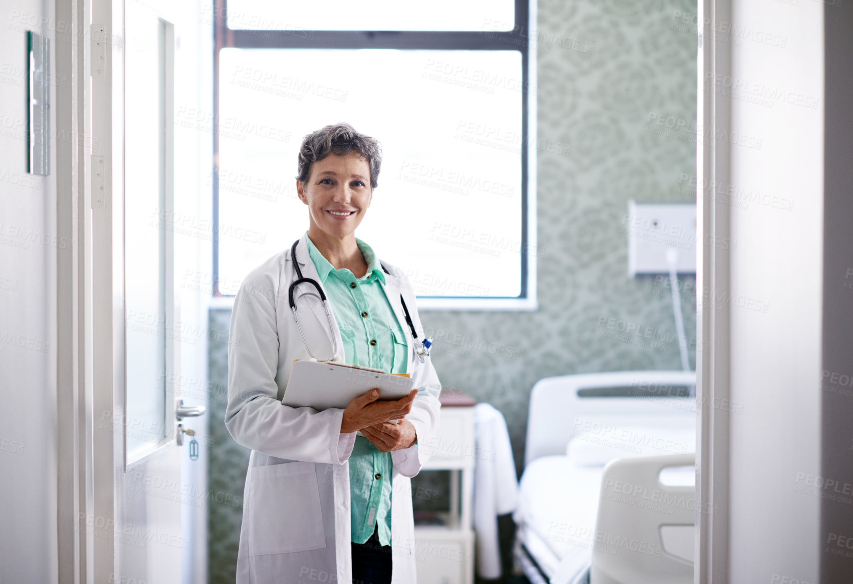 Buy stock photo Portrait of a mature female doctor standing in a hospital ward