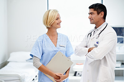 Buy stock photo Shot of two medical professionals talking together in a hospital ward