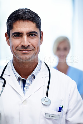 Buy stock photo Portrait of a male doctor with a colleague in the background