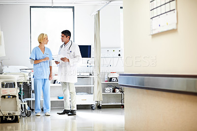 Buy stock photo Shot of two doctors talking in a hospital corridor