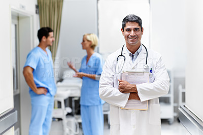 Buy stock photo Portrait of a confident doctor with medical staff in the background