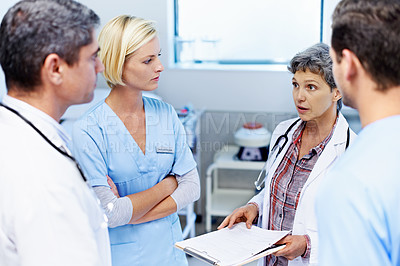 Buy stock photo Shot of a group of medical professionals having a discussion in a hospital corridor