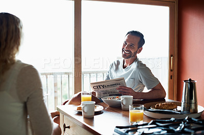 Buy stock photo Shot of a man and his wife having breakfast in their kitchen