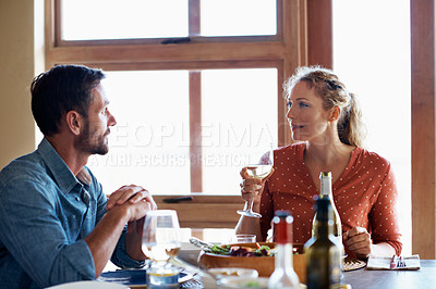 Buy stock photo Shot of a couple having dinner in their living room