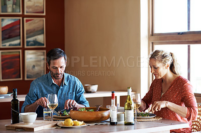 Buy stock photo Shot of a couple having dinner in their living room