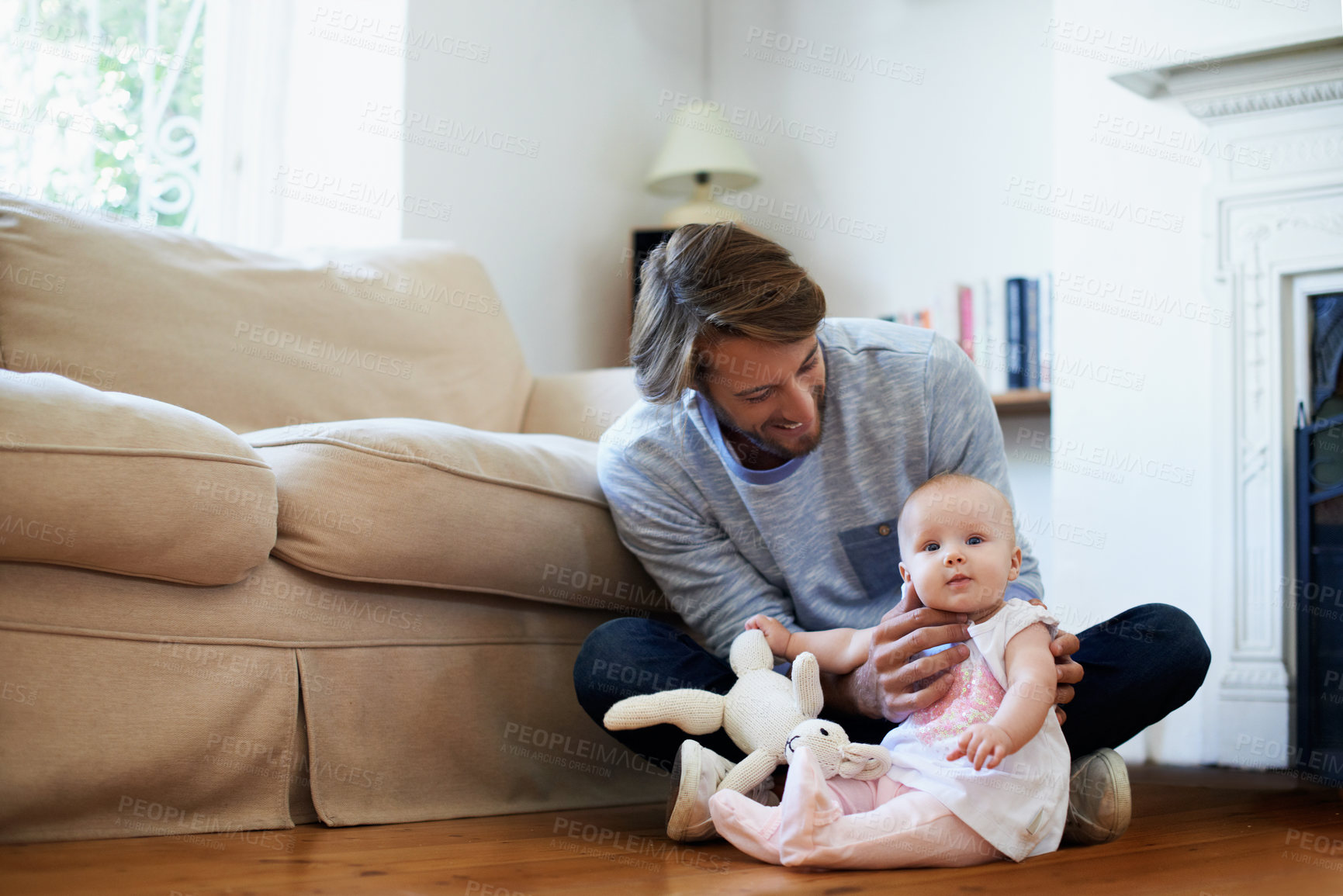 Buy stock photo Shot of a smiling father playing with his baby girl at home