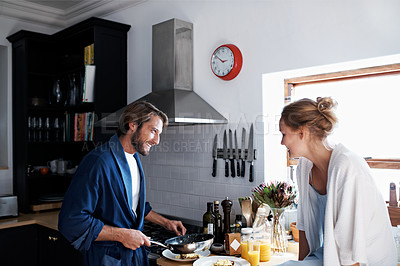Buy stock photo Shot of a young couple making breakfast together in the kitchen