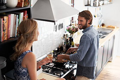 Buy stock photo Shot of a young couple cooking together in the kitchen