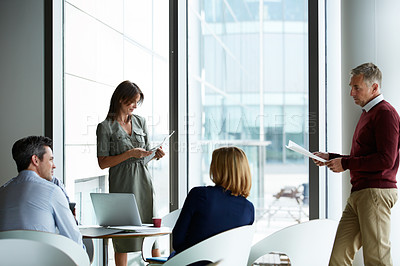 Buy stock photo Shot of a group of colleagues talking together in a modern office