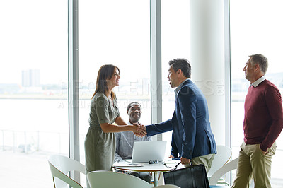 Buy stock photo Shot of a two colleagues shaking hands during a meeting