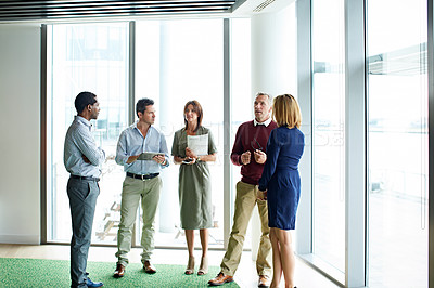 Buy stock photo Shot of a group of colleagues talking together in a modern office