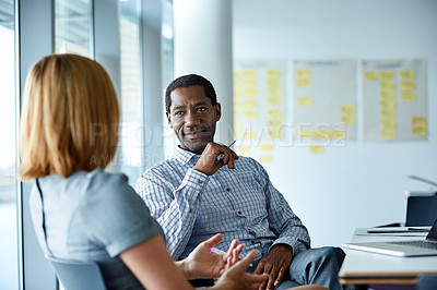 Buy stock photo Shot of two colleagues talking together in a modern office
