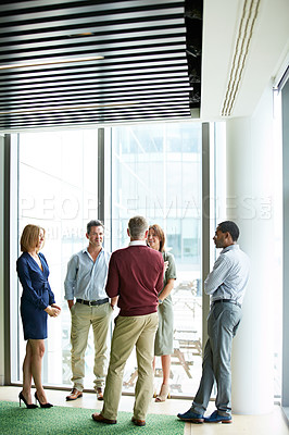 Buy stock photo Shot of a group of colleagues talking together in a modern office