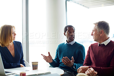 Buy stock photo Shot of three colleagues having a meeting in an office