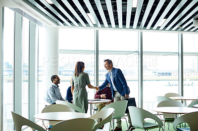 Buy stock photo Shot of a two colleagues shaking hands during a meeting