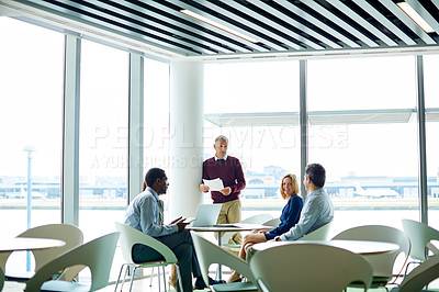 Buy stock photo Shot of a group of colleagues talking together in a modern office