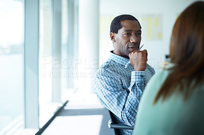 Buy stock photo Shot of two coworkers talking together while sitting in an office