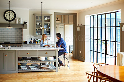 Buy stock photo Shot of a young couple having breakfast in their kitchen