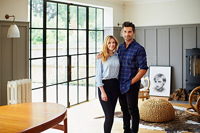 Buy stock photo Portrait of a young couple standing in their living room