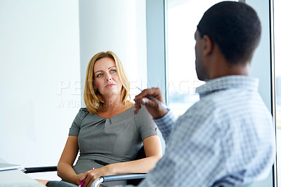 Buy stock photo Shot of two colleagues talking together in a modern office