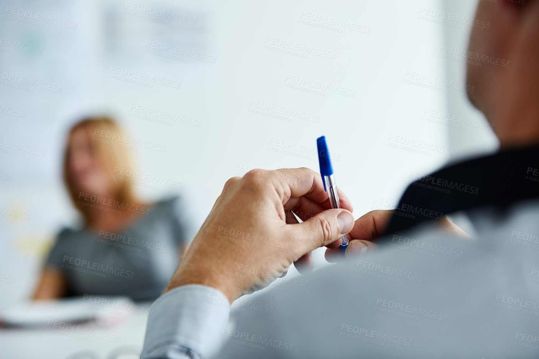 Buy stock photo Closeup shot of a businessman holding a pen while sitting in the boardroom