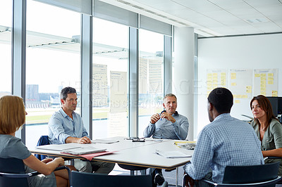 Buy stock photo Shot of a group of colleagues talking together in a modern office
