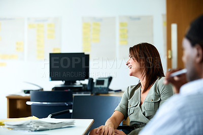 Buy stock photo Shot of a smiling businesswoman sitting with a colleague in an office