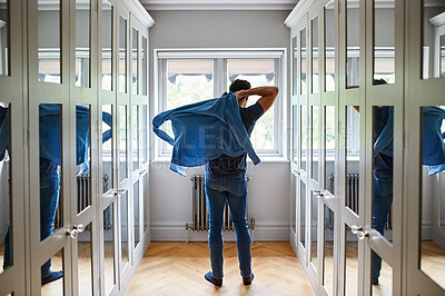Buy stock photo Shot of a man getting dressed in a long walk in closet full of mirrors