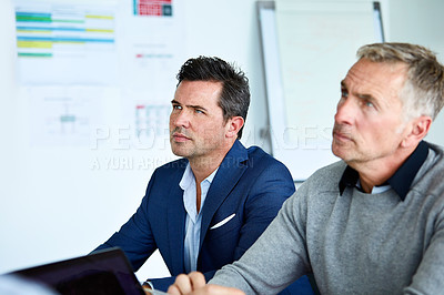 Buy stock photo Shot of two coworkers listening to a presentation druing a meeting in an office