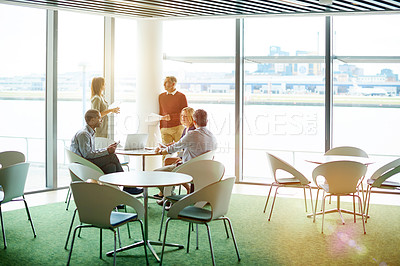 Buy stock photo Shot of a group of colleagues talking together in a modern office