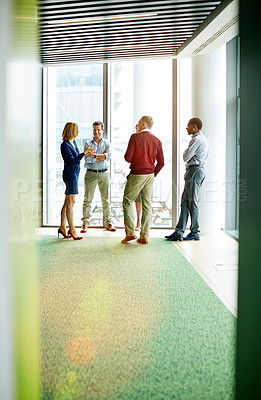 Buy stock photo Shot of a group of colleagues talking together in a modern office