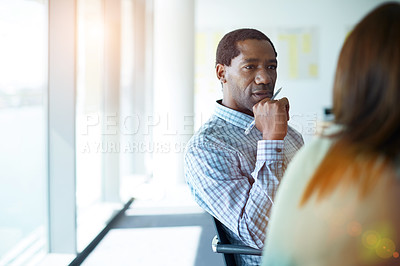 Buy stock photo Shot of two coworkers talking together while sitting in an office