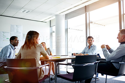 Buy stock photo Shot of colleagues having a meeting around a boardroom table in an office