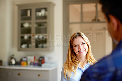 Buy stock photo Shot of a young couple drinking talking together in their kitchen