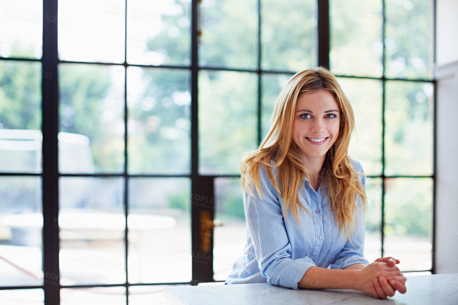 Buy stock photo Portrait of a young woman leaning on her counter at home