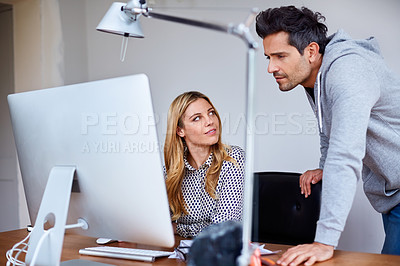 Buy stock photo Shot of a young couple working together in their home office