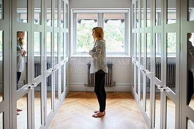 Buy stock photo Shot of a woman getting dressed in a long walk in closet full of mirrors