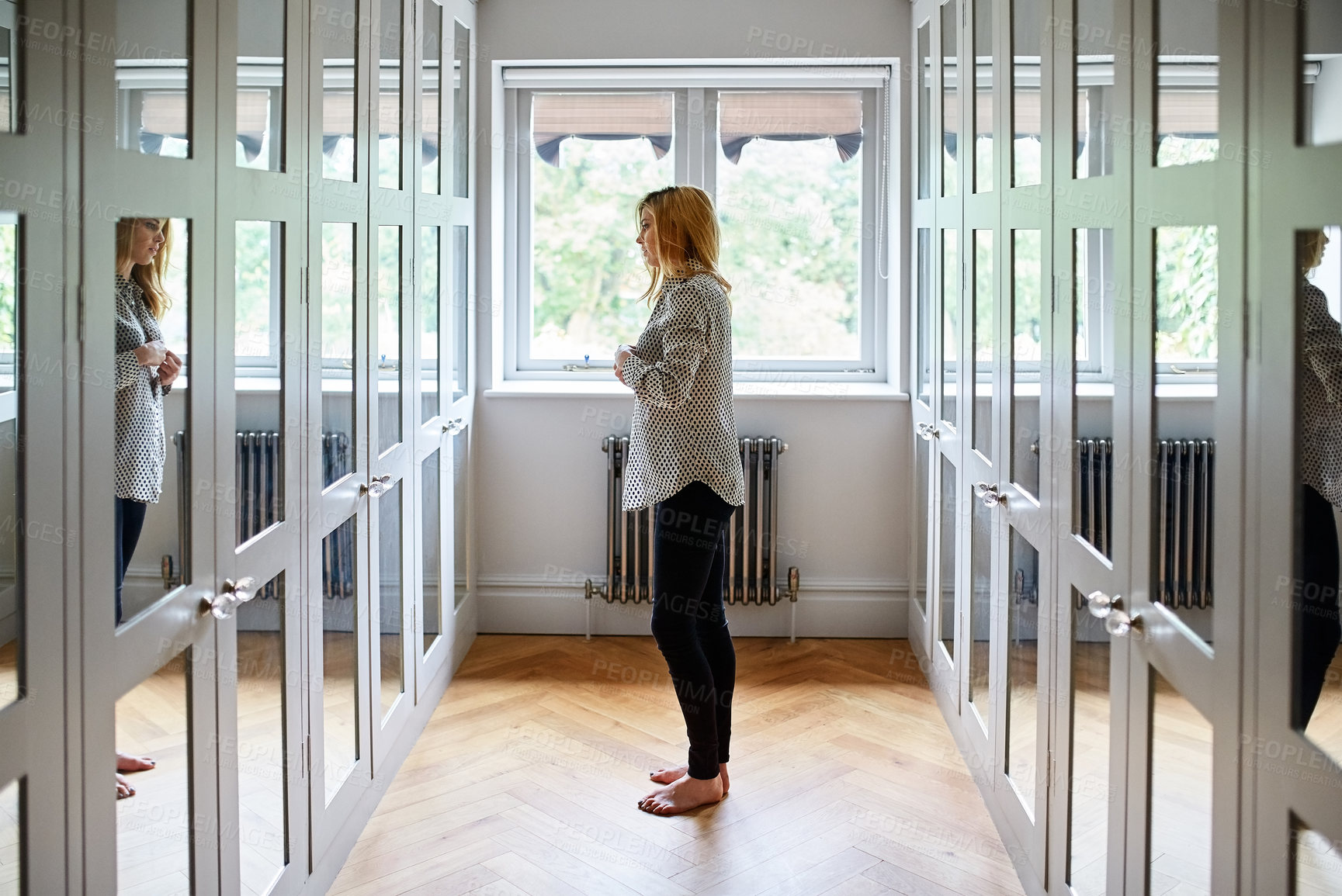 Buy stock photo Woman, mirror and dressing with clothing in closet for fashion, routine or preparation in home. Styling, female person or getting ready in corridor with wardrobe, window or reflection in house