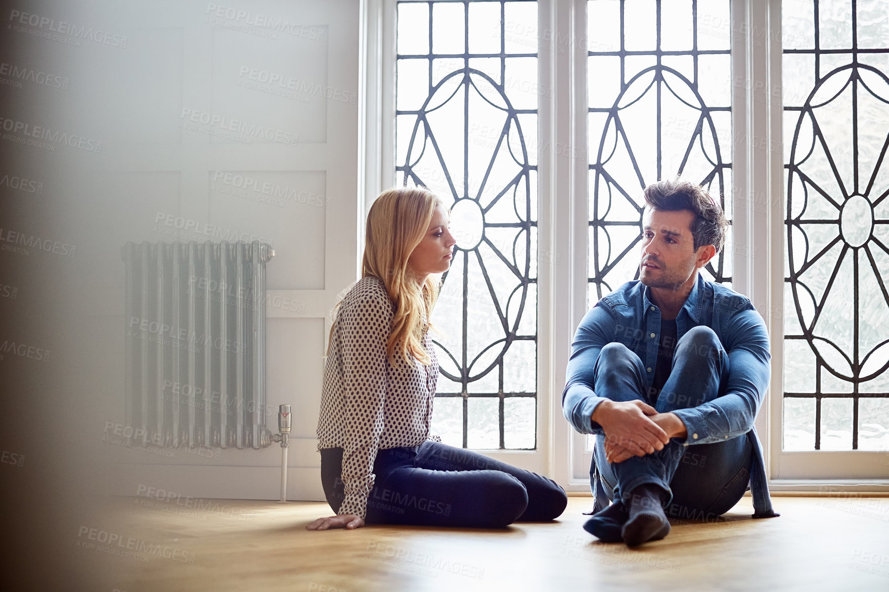 Buy stock photo Couple, mental health and support in home with communication, care and listening to serious talk. House, woman and man with depression share story with partner for help, conversation or trauma memory