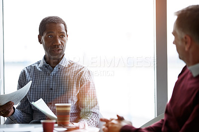 Buy stock photo Shot of two coworkers talking together while sitting in an office