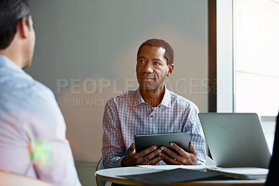 Buy stock photo Shot of two coworkers talking together while sitting in an office