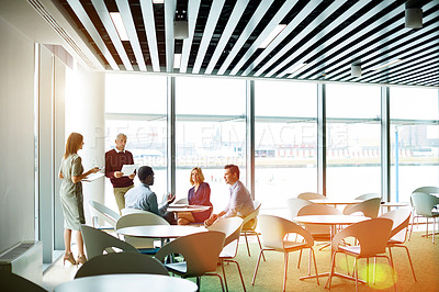 Buy stock photo Shot of a group of colleagues talking together in a modern office