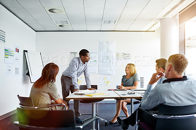 Buy stock photo Shot of a man giving a presentation to colleagues in an office boardroom