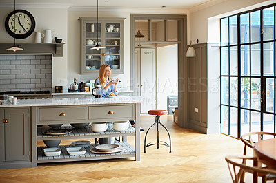 Buy stock photo Shot of a young woman drinking coffee and eating breakfast in her kitchen