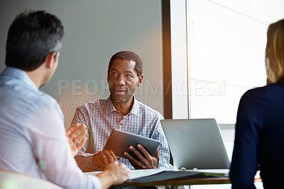Buy stock photo Shot of a group of coworkers talking together while sitting in an office